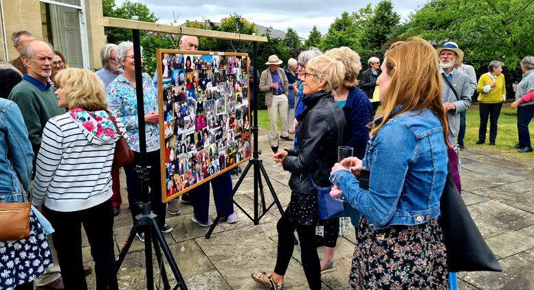 Looking at the board where funeral-goers pinned their pictorial mementoes